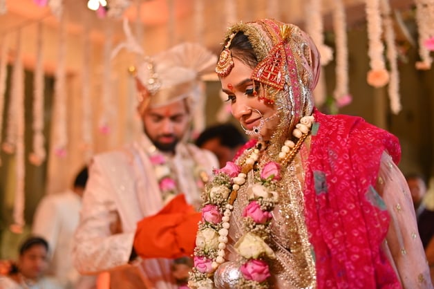 The bride and groom exchanging vows during the traditional seven vow ceremony, beautifully captured by Fotographiya