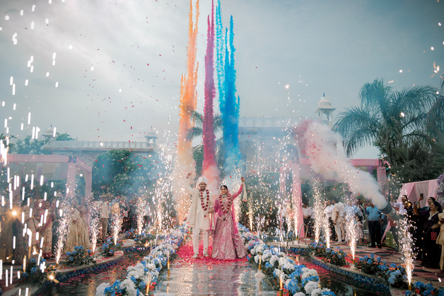 The vibrant Varmala ceremony on the wedding day, capturing the couple exchanging floral garlands, photographed by Fotographiya