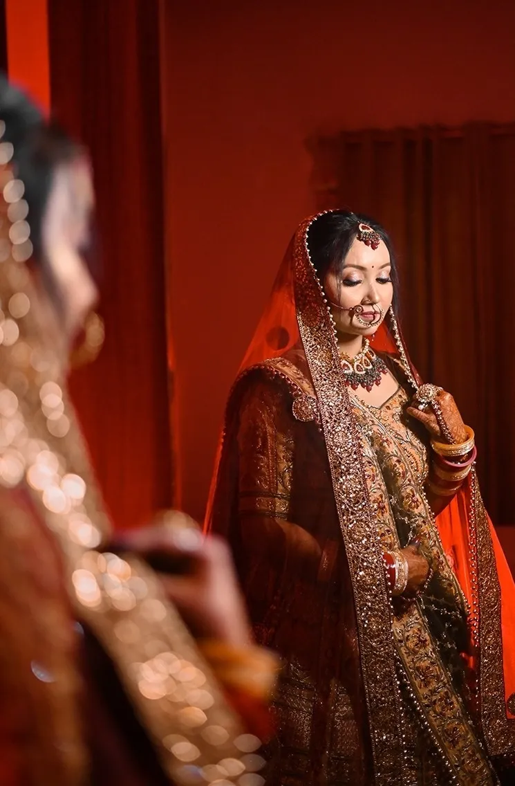 A bride admiring herself in the mirror during a bridal photography session, captured by Fotographiya