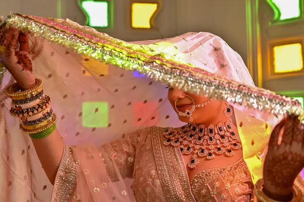 A creative and elegant portrait of an Indian bride, highlighting her intricate attire and traditional makeup