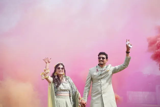 A couple joyfully dancing during the Haldi ceremony, capturing the vibrant and festive atmosphere