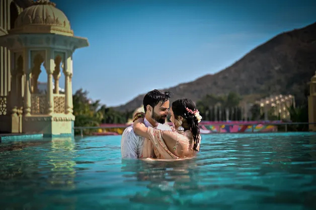 A romantic couple embracing during a sunset photoshoot, captured by Fotographiya